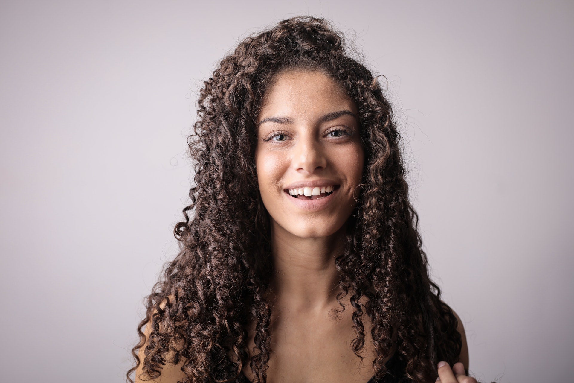 smiling woman with brown curly hair