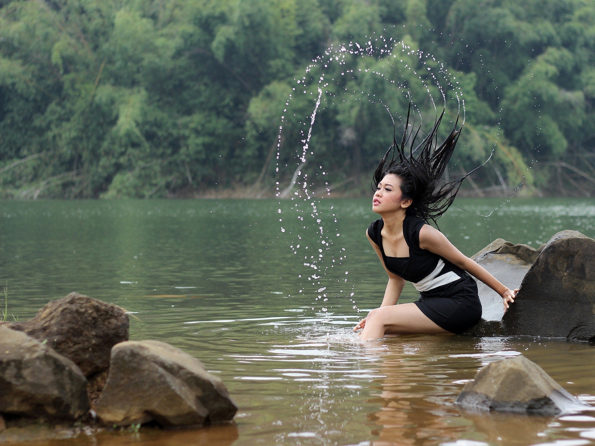 woman outside flipping hair in lake water