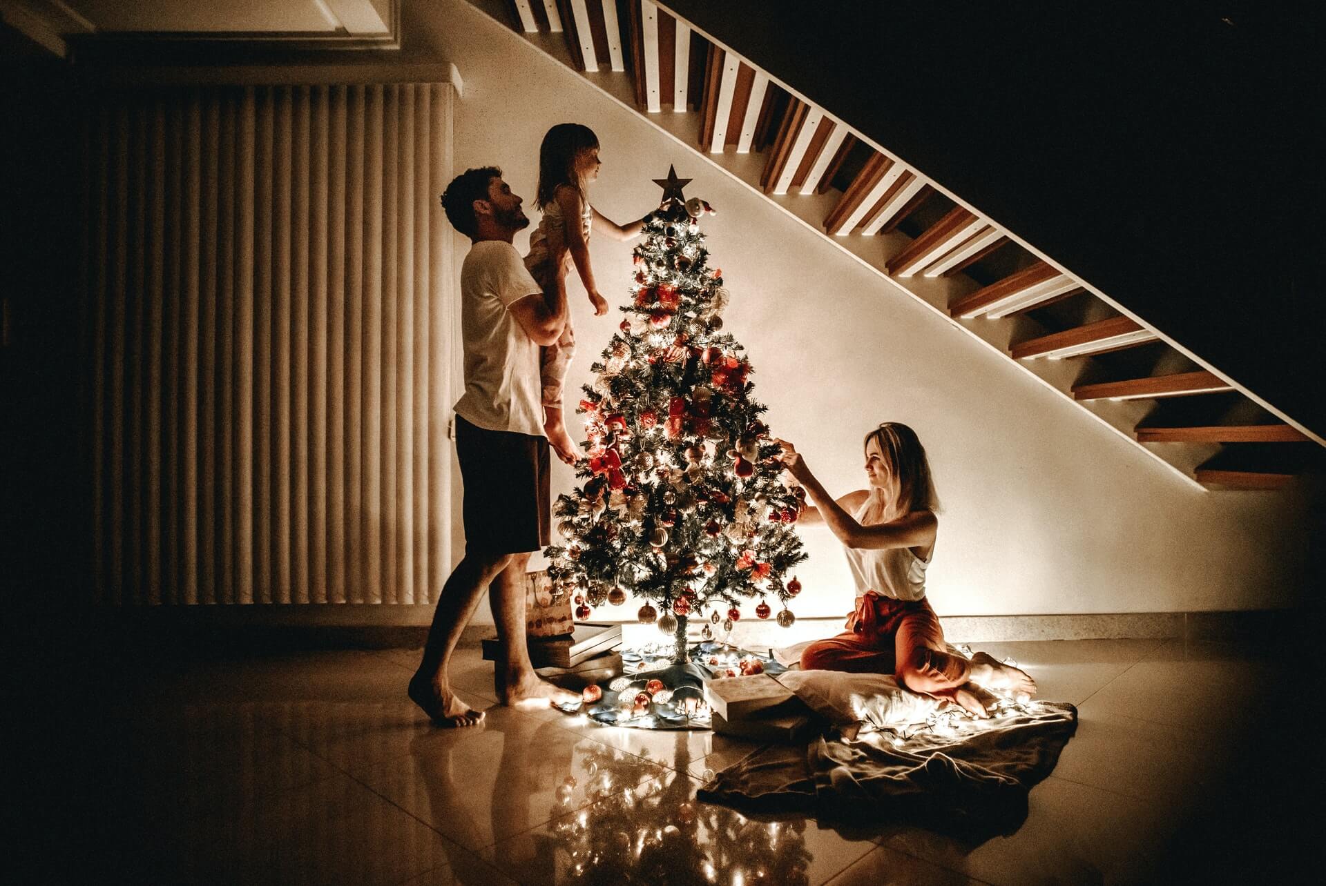 family lighting the christmas tree