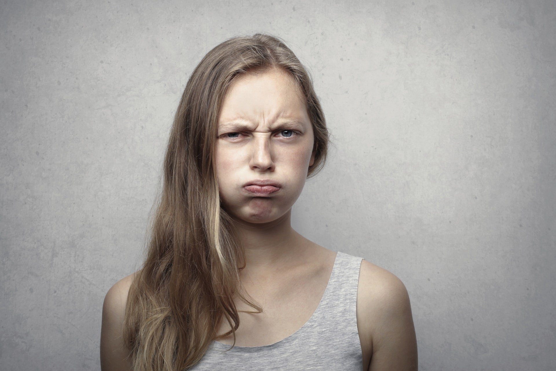 woman in tank top frowning