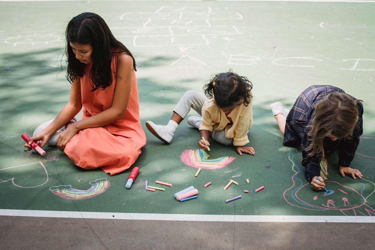 kids writing in chalk outside