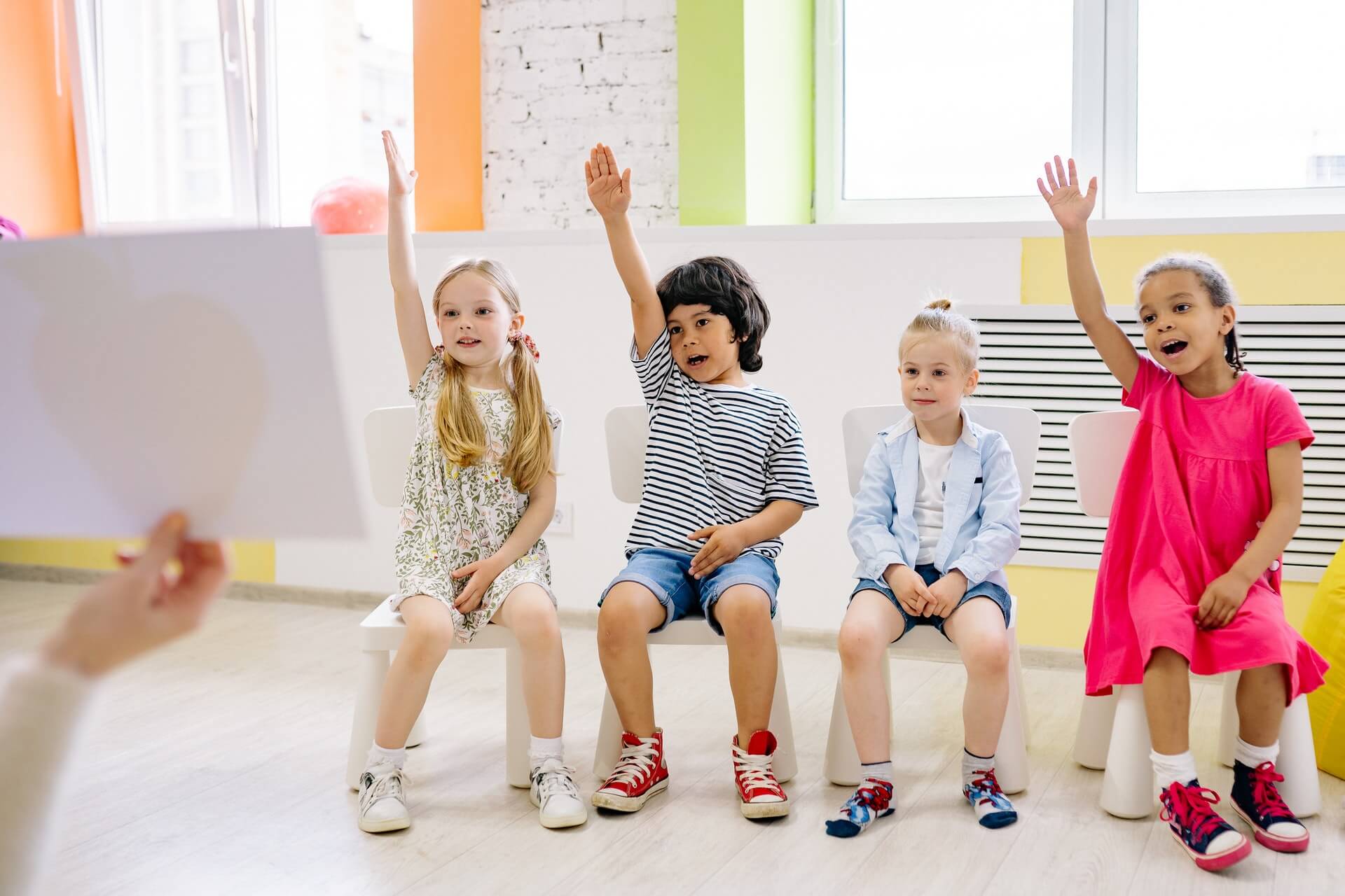 kids raising hands in class