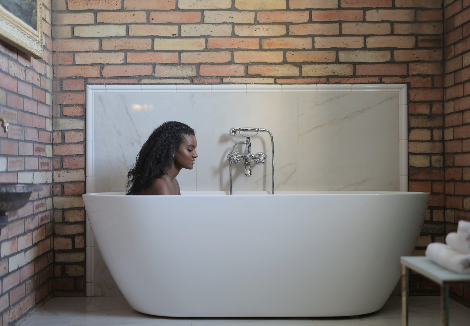 woman soaking in large white bathtub